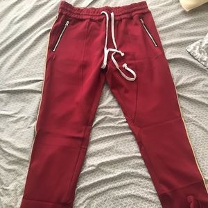 Men’s red striped jogger track pants. Elastic waistband with draw cord.